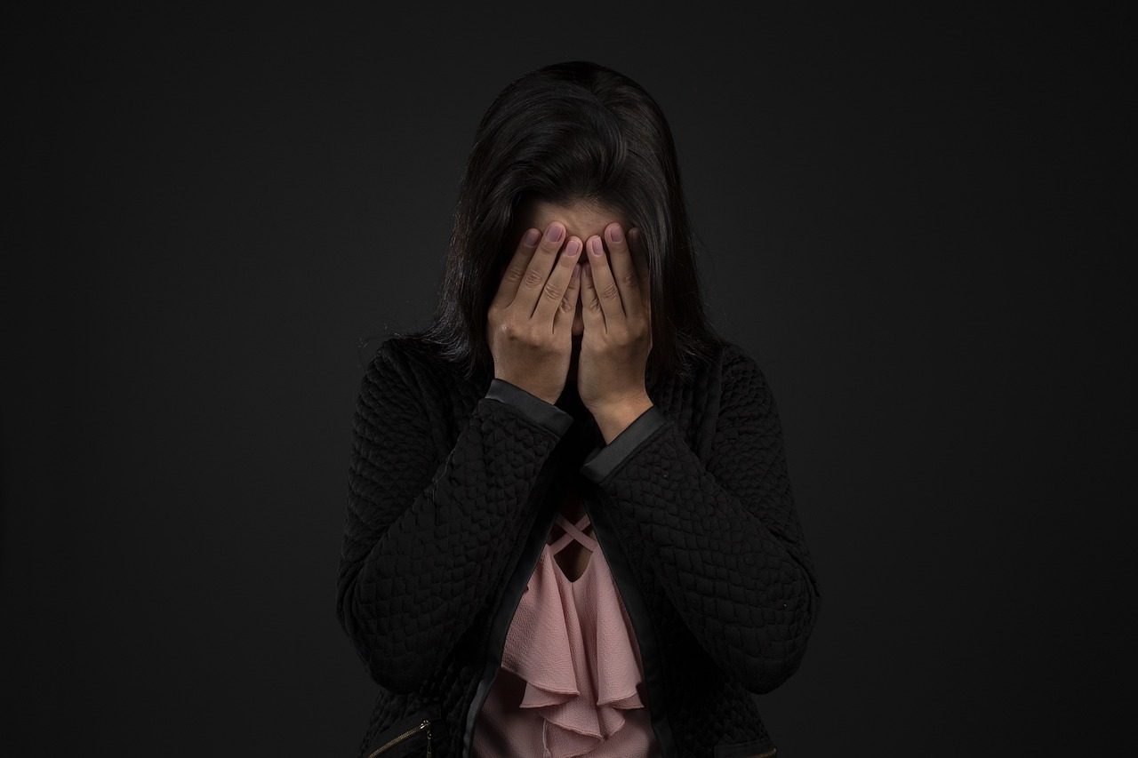 una donna depressa con le mani sul volto